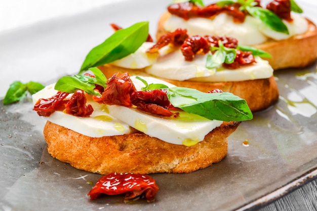 Gustosi stuzzichini italiani, o bruschette, su fette di baguette tostate guarnite con basilico