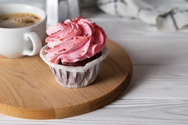 Gustoso cupcake con glassa di ciliegia con tazza di caffè