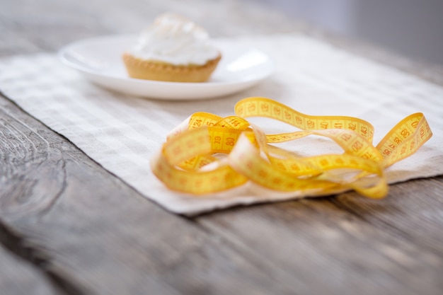 Gustoso dessert. Messa a fuoco selettiva di una torta cremosa in piedi dietro il nastro centimetrico