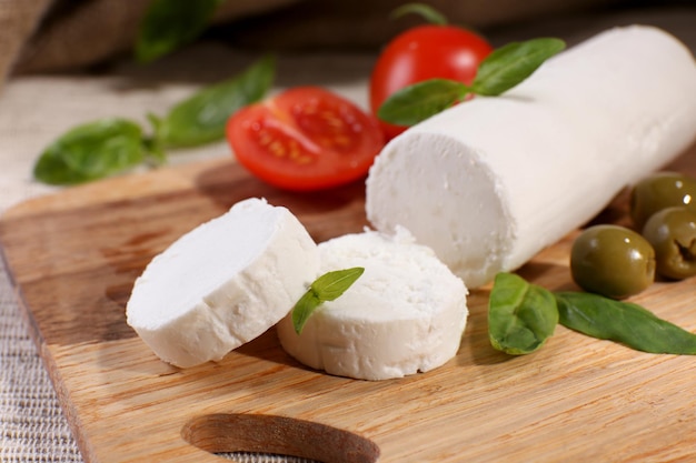 Gustoso formaggio bushe con pomodori olive e basilico sul tagliere