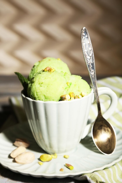 Gustoso gelato al pistacchio in tazza sulla tavola di legno