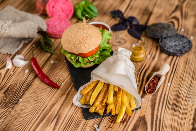Gustoso hamburger con carne e verdure contro uno sfondo scuro. Fast food. Può essere usato come sfondo