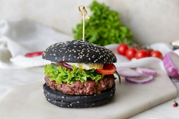 Gustoso hamburger con panino nero sul tavolo