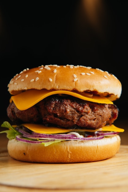Gustoso hamburger di manzo alla griglia con formaggio, cipolla e lattuga. Foto Premium