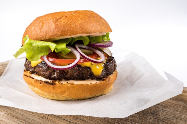 Gustoso hamburger fatto in casa composto da panino, formaggio, insalata, cipolla rossa e pomodoro