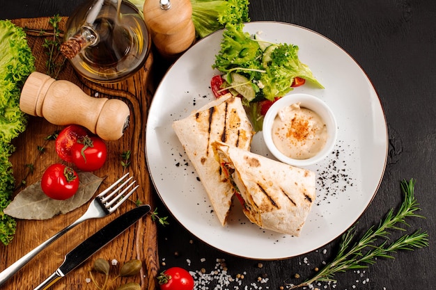 Gustoso piatto di pita con carne e verdure su fondo di legno