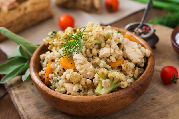 Gustoso porridge di orzo di perle con verdure e pollo