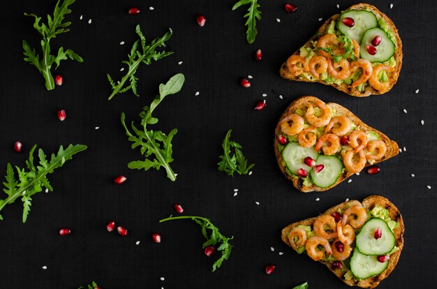 Gustoso spuntino sano con toast di avocado, cetrioli e gamberi