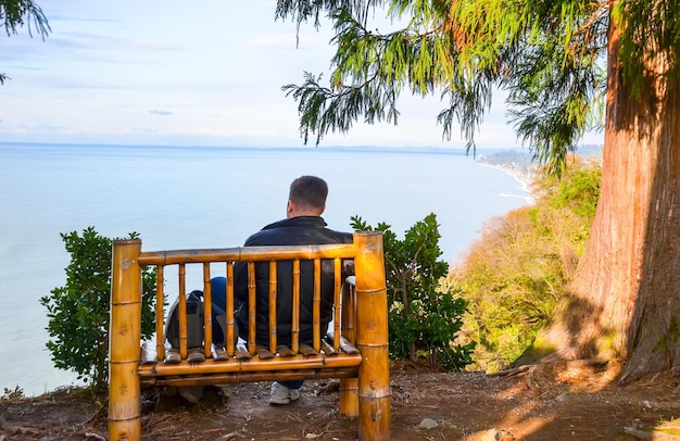 Guy gode di una vista sul Mar Nero sul banco del giardino botanico Georgia Batumi