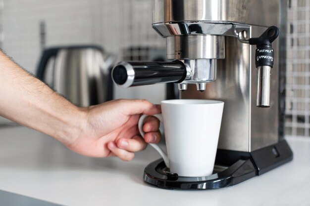 Guy prepara delizioso caffè aromatico in una macchina da caffè. Un modo semplice per fare il caffè