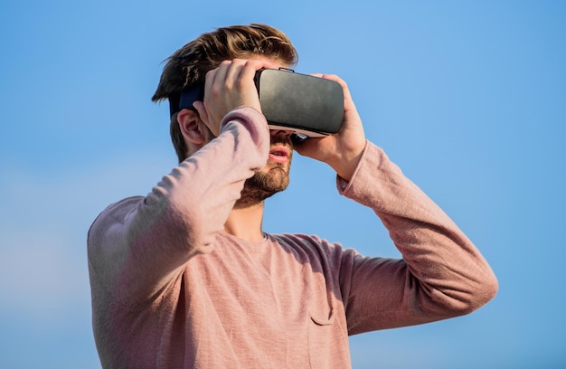 Guy realtà virtuale Nel mio mondo virtuale uomo macho indossare occhiali VR wireless realtà maschile La tecnologia futura crea il proprio business Futuro digitale e innovazione uomo sexy sfondo del cielo occhiali vr