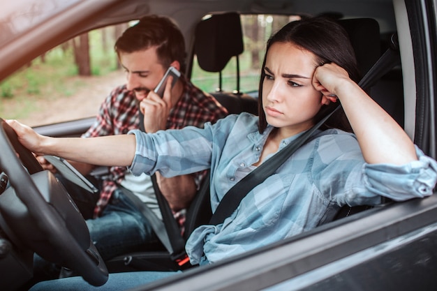 Guy sta parlando al telefono e ride mentre la ragazza sta guidando la macchina