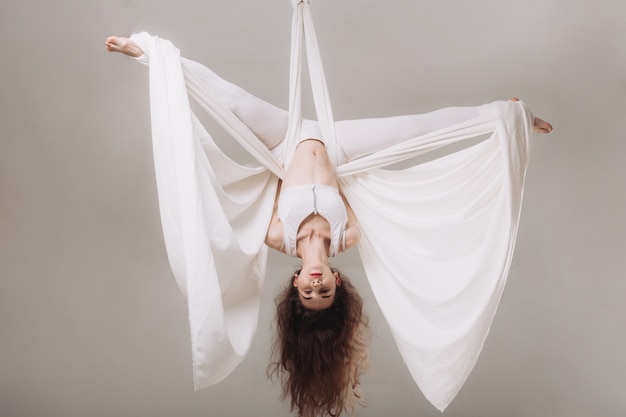 Gymnast femminile facendo acrobazie aeree di seta