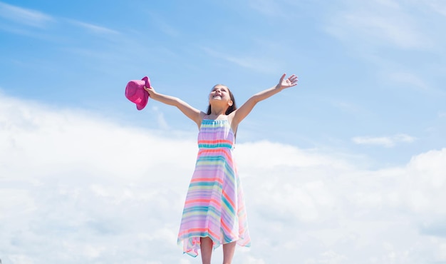 Ha ottenuto un grande stile piccola ragazza ha i capelli lunghi e lussureggianti bambino in abito femminile salone di parrucchiere bellezza e moda estiva bambino allegro sullo sfondo del cielo bambino alla moda all'aperto infanzia felice