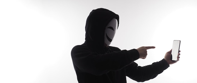 Hacker Anonymous e maschera facciale con smartphone in mano