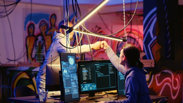 Hacker che lasciano una base dipinta di graffiti nascosti dopo essere riusciti a rubare numeri di carte di credito e manipolare i sistemi bancari Programmatori malvagi che riescono nella loro missione di hacking abbandonando il quartier generale