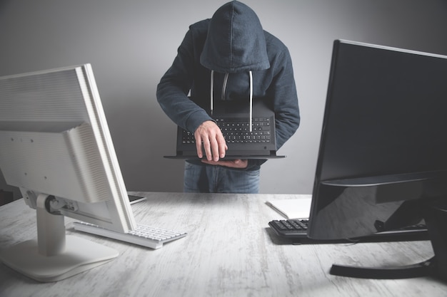 Hacker che ruba informazioni dal computer dell'ufficio.