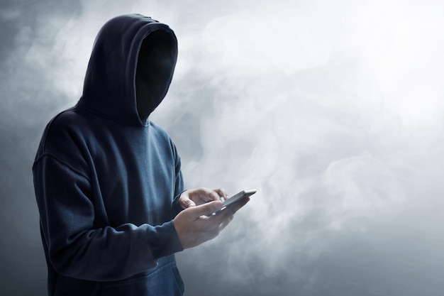 Hacker che usa il telefono cellulare