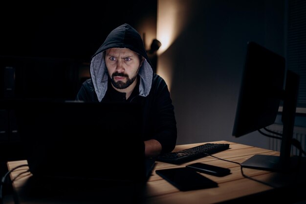 Hacker che utilizza il computer portatile in camera oscura