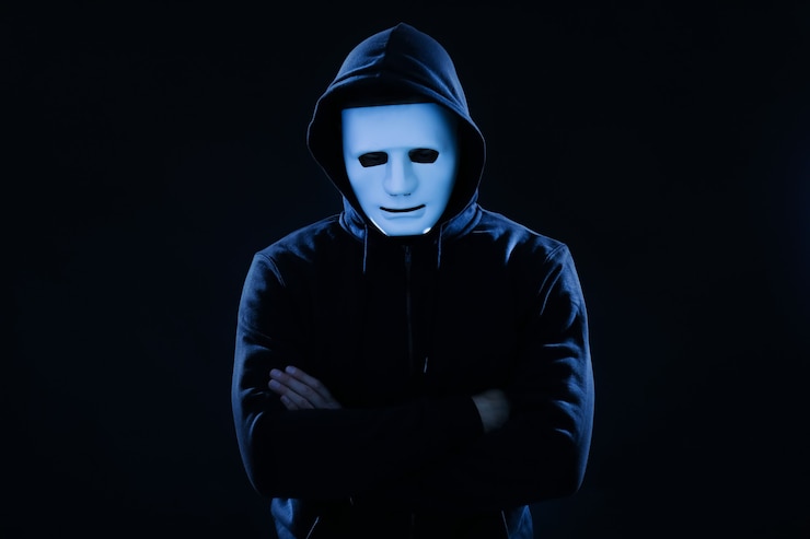 Foto hacker con maschera su superficie scura