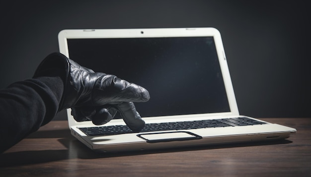 Hacker con un guanto di pelle con un computer