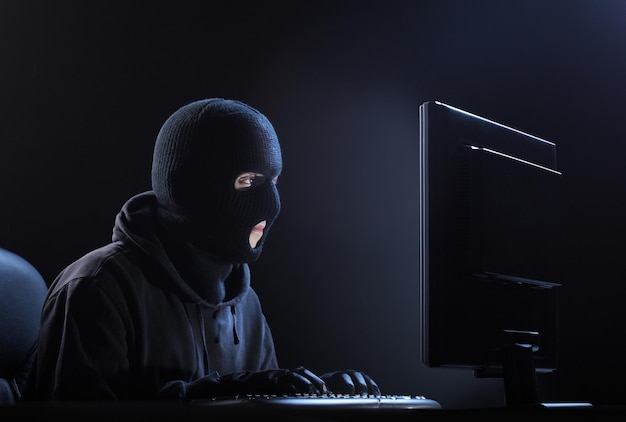 Hacker di computer ladro maschio che ruba dati dal computer