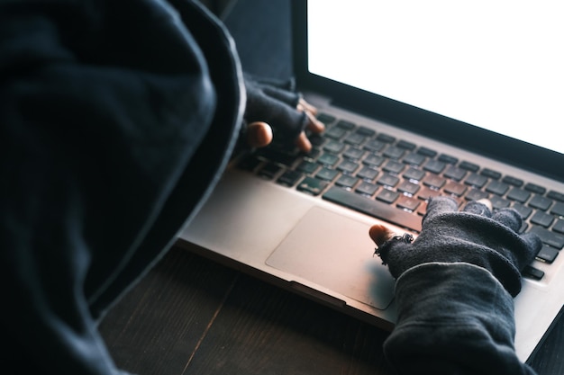Hacker hand stealing data from laptop top down