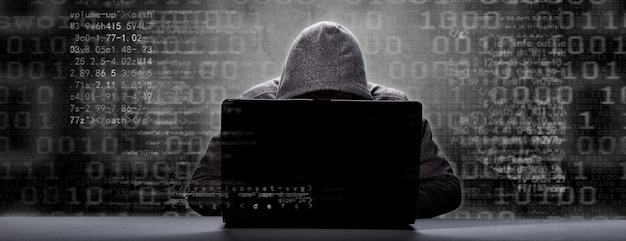 Hacker stampa un codice sulla tastiera di un laptop per entrare in un cyberspazio