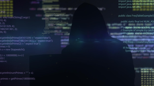 Hacker uomo irriconoscibile che indossa una felpa con cappuccio che scrive sul tastiera codice di programmazione