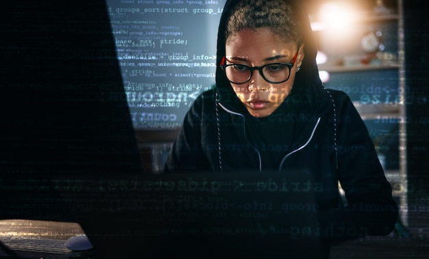 Hacker woman in dark room with laptop and code data analysis and IT phishing and cyber crime with database Cybersecurity programming and criminal with pc overlay or hologram with ransomware