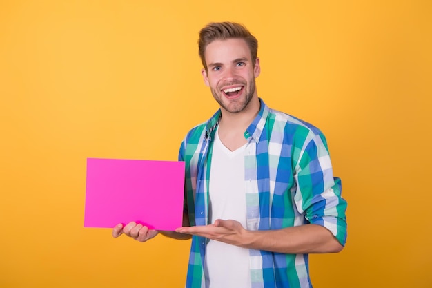 Hai bisogno di questo prodotto Il ragazzo felice tiene il foglio rosa e la mano aperta Presentazione del prodotto Promozione del prodotto Marketing e vendite Spazio pubblicitario del prodotto