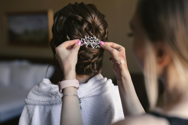 Hair stylist e truccatrice preparano una sposa per il giorno del matrimonio