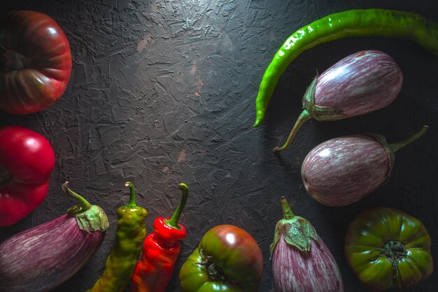 Halfframe di pomodori multicolori melanzane e peperoncino su un tavolo grigio