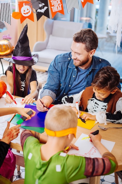 Halloween a casa. Padre amorevole bello che si sente incredibilmente felice mentre celebra Halloween a casa