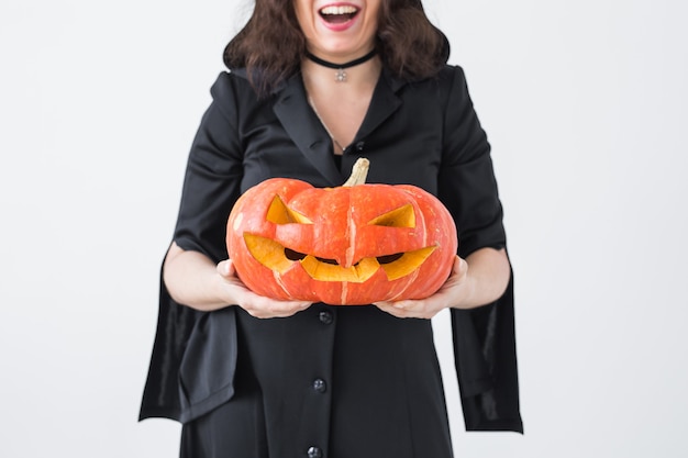 Halloween e concetto di feste - donna della strega con la zucca di Jack O'Lantern.