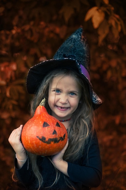 Halloween la ragazza ride e tiene una zucca in mano