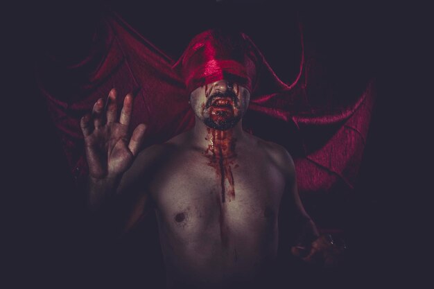 Halloween, uomo nudo su un grande panno rosso sopra gli occhi