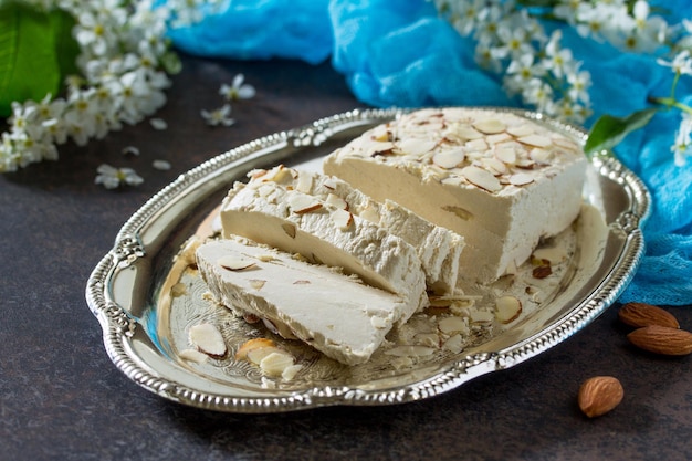 Halva con petali di mandorla sul tavolo della cucina. Dolci turchi e arabi. Mangiare il Ramadan.