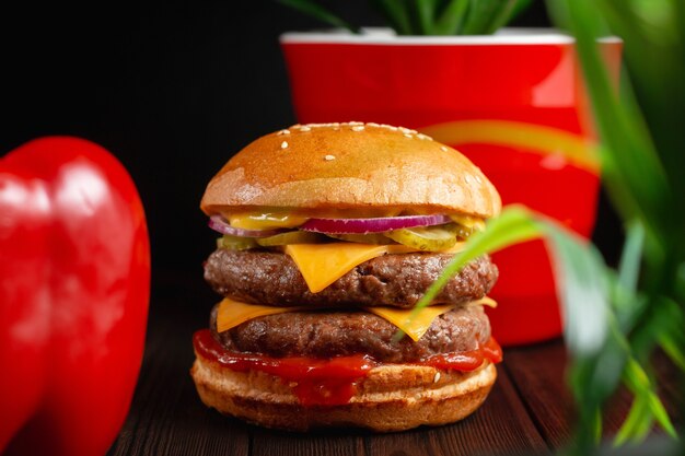 Hamburger alla griglia luminosi e succosi con manzo e formaggio cheddar. Concetto di fast food