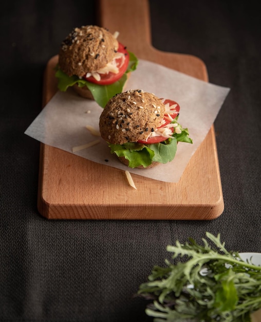 Hamburger appetitosi con insalata di pomodoro e formaggio su un panino senza glutine Concetto di alimentazione sana