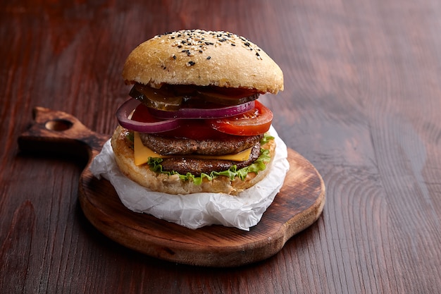 Hamburger appetitoso sul tavolo su un tavolo di legno scuro