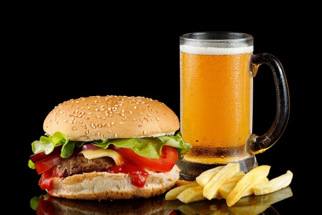 Hamburger con birra e patatine fritte Hamburger con isolato di birra sul nero