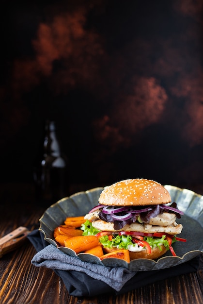 hamburger con filetto di pollo alla griglia, paprika, patate dolci, lattuga, cipolle e yogurt greco