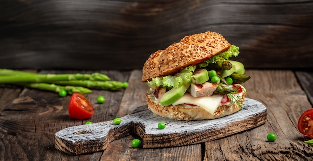 hamburger con filetto di pollo, asparagi, avocado, pomodori, piselli, formaggio e tartare