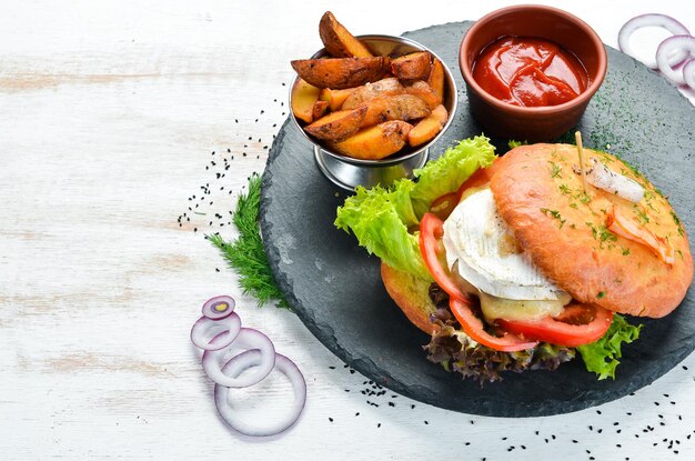 Hamburger con formaggio camembert e carne Patatine fritte e ketchup Vista dall'alto spazio libero per il testo Stile rustico