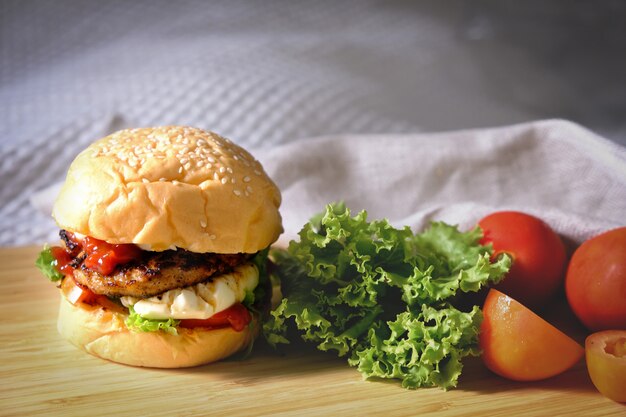 Hamburger con formaggio, insalate e verdure su uno spazio bianco