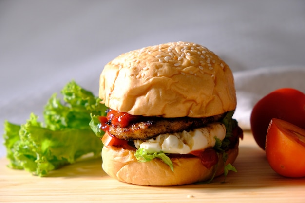 Hamburger con formaggio, insalate e verdure su uno spazio bianco