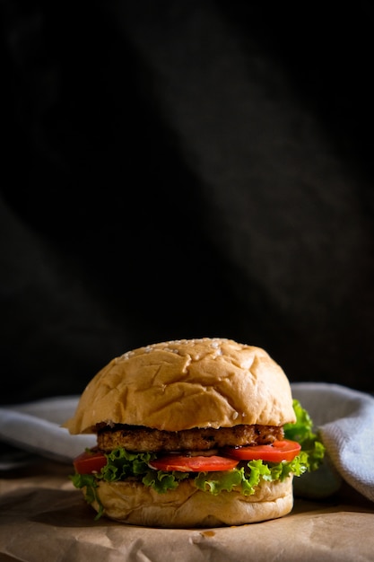 Hamburger con formaggio, insalate e verdure su uno spazio nero