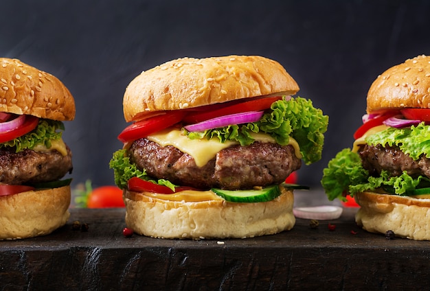 Hamburger con hamburger di carne di manzo e verdure fresche su sfondo scuro. Cibo gustoso.