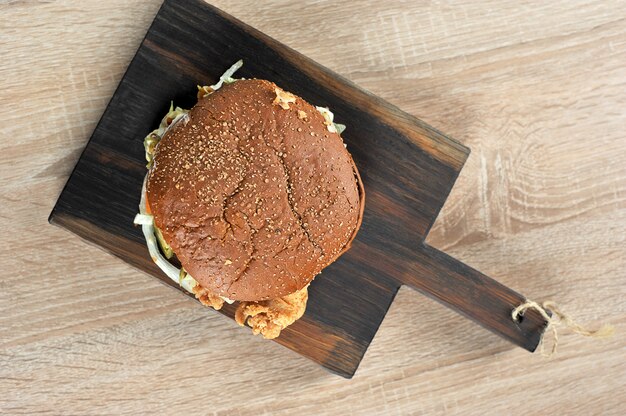 Hamburger con pane scuro sul bordo di legno